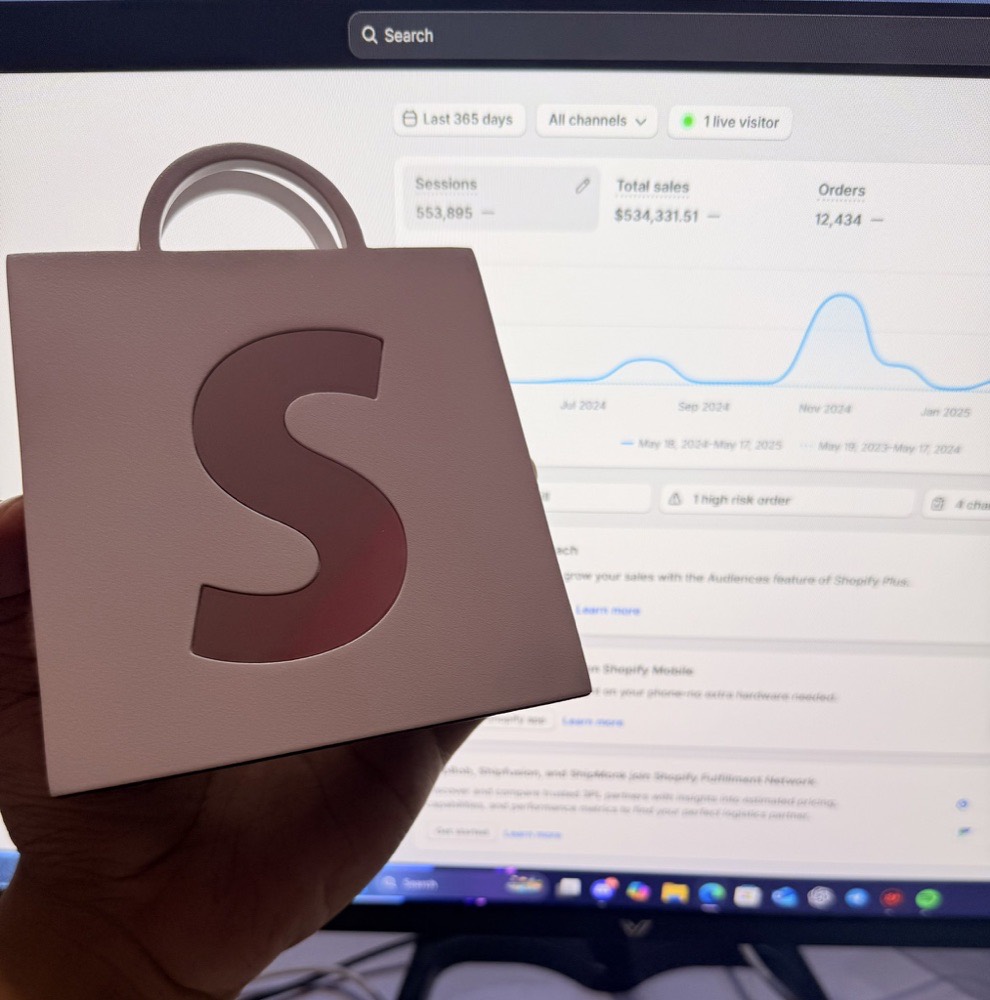 Holding the Shopify milestone plaque